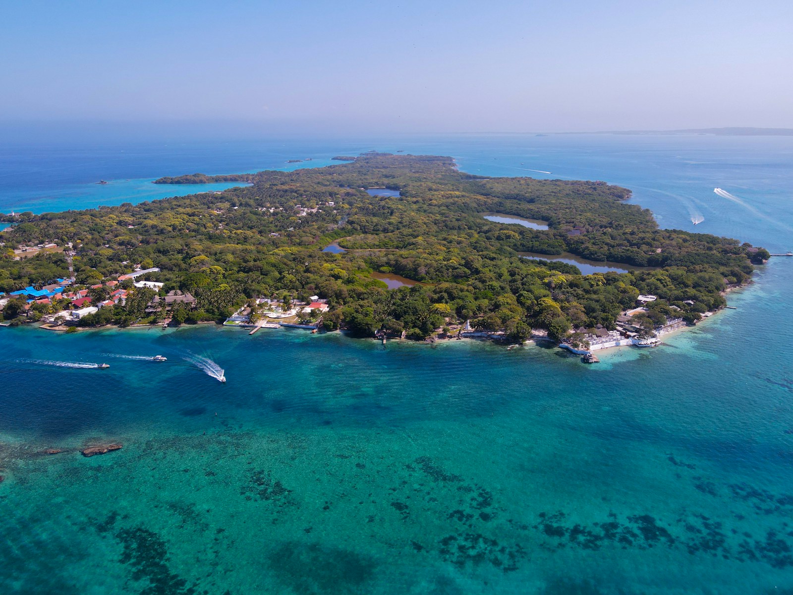 Aerial view of Isla Grande in the Rosario Islands, surrounded by turquoise reefs and small motorboats